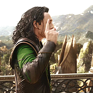 Tom Hiddleston playing Loki angrily turning around while holding up his index finger looking like he may break into a laugh.